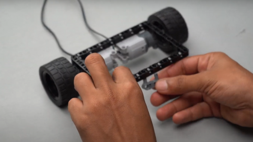 Pin connector attached to the opposite side of the motors on the block, demonstrating how to build the framework for an effective line follower robot.