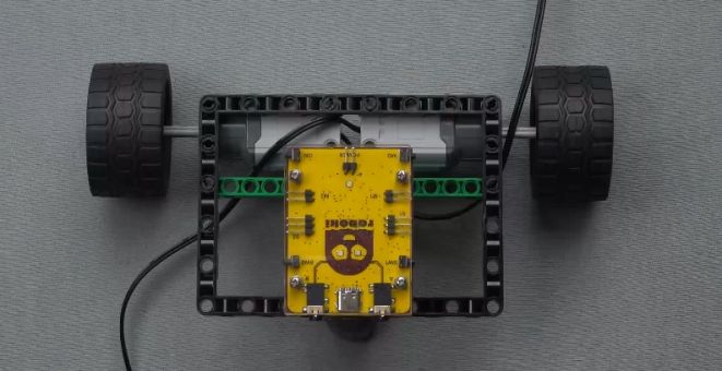 Next, connect the Roboki on top of the structure as shown in the image, using the bricks on the underside of the robot to align with the central beam and secure it in place by applying pressure. During this step, ensure you support the body of the bot from below to prevent any damage to your innovative Roboki car design. This essential step is part of a hands-on robotic project that enhances your understanding of mobile robot construction and programming, making it an ideal activity for robotics enthusiasts and beginners exploring STEM education.