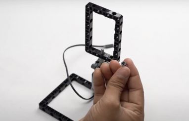 Now, place a full bush on top of the block and onto the axle to secure it properly, ensuring the stability of the motorized game in this STEM robotics activity.