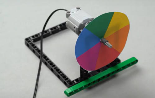 Now onto our spin wheel robot, a STEM robotic project for beginners and robotic enthusiasts, the colored spin wheel is attached to the axle, and then another full bush is added to secure the wheel in place.