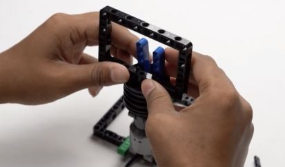 Fix the 11 by 7 block onto the pin connector to complete the mobile holder mounted on the motor. This step is essential for ensuring your AI-powered robot can effectively detect and identify objects.