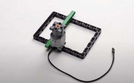 Connect the motor to the block and beam as shown in the image, integrating the motor into your AI-powered Object Finder Robot. This construction enhances the robot's mobility and functionality in detecting objects.