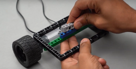 Mount a 1 by 6 brick with holes onto Beam 5 by attaching two 90-degree pegs, forming a crucial support structure for the emotion detecting pet robot. This step showcases advanced robotics principles in constructing companion robots that utilize emotion detection and autonomous robot ideas for a truly interactive experience.