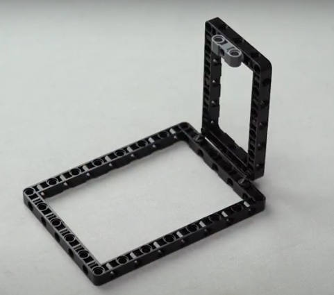 Onto the frame we have built for our spin wheel robot, a technic pin connector is attached on the 11 by 7 technic block.