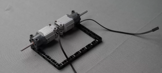 Attaching axle 5 to each motor to prepare the Follow Me Home robot for wheel mounting, enhancing mobility with Roboki's precise control for object detection.