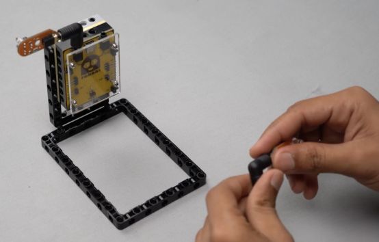 Attach another proximity sensor to Port B of the Roboki microcontroller using angled port connectors, ensuring a secure connection while facing forward. This setup is vital for the Entry Guard bot, facilitating effective real-time traffic flow detection and automated management in this hands-on STEM robotics project for beginners and robotic enthusiasts.