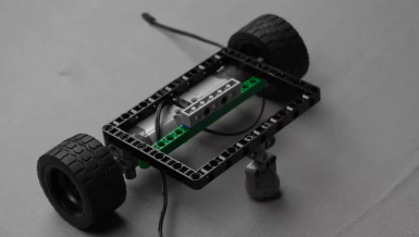 Attaching a 1 by 6 brick with holes and two 90-degree pegs to Beam 5, demonstrating a step in building a wall detecting bot. This project illustrates the exciting world of robotic projects, offering insights into STEM education through robotic and electronics projects designed for aspiring robotic project enthusiasts.