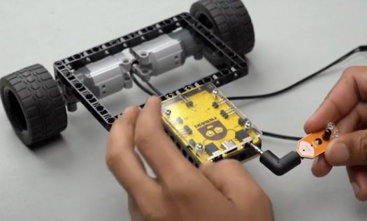 The image demonstrates the process of connecting a proximity sensor to Roboki's ports in the line follower robot project. This crucial step enhances the robot's capabilities, making it an excellent example of robotics skills development for budding engineers and tech enthusiasts interested in autonomous bots and DIY robotics.