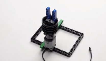 Similarly, take another Beam 5 and attach it to the second peg on the pin connector, fixing it onto the rim on the axle. This assembly contributes to the design of the mobile bot's framework.