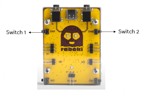 Roboki microcontroller with two labeled inbuilt switches displayed against a white background, highlighting its interactive controls.