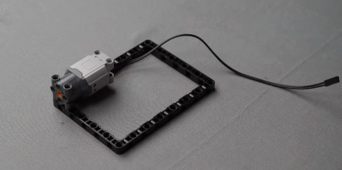 Connect the motor to this block as shown in the image, an important step in the Robo car assembly process, showcasing mobile robot programming and design principles in this engaging DIY robotics project for beginners exploring innovative robotic concepts.