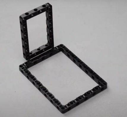 Two 90-degree pegs attached to the 11 by 7 block, which is then secured to the 15 by 11 block, illustrating key assembly steps for the Entry Guard bot, a hands-on project in sensor-based systems and robotics for beginners